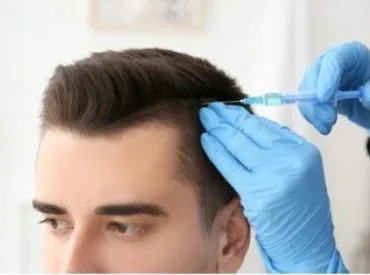 Male head and hands in gloves holding syringe